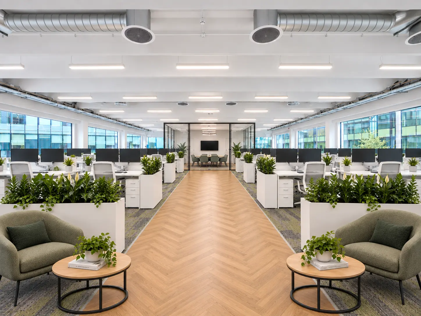 Bright fitted office with desks, meeting room, plants and breakout seating